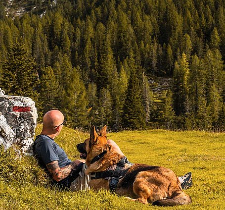 Wanderer mit Hund bei Rast