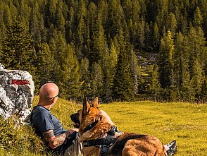 Wanderer mit Hund bei Rast