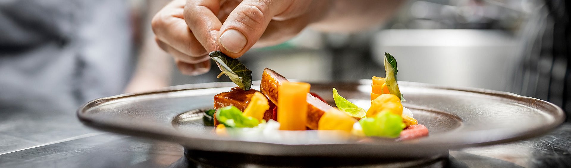 Koch beim Anrichten der Hauptspeise