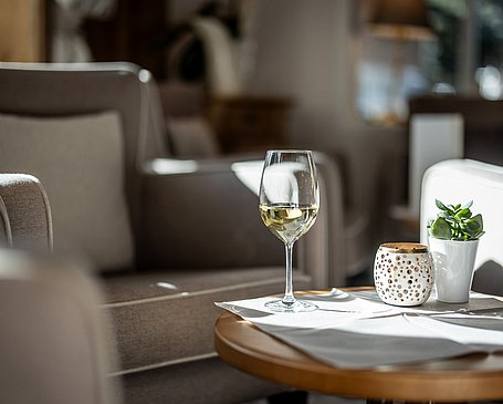 Tisch in der Lobby mit einem Glas Weißwein