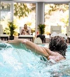Mann schwimmt im Hallenbad
