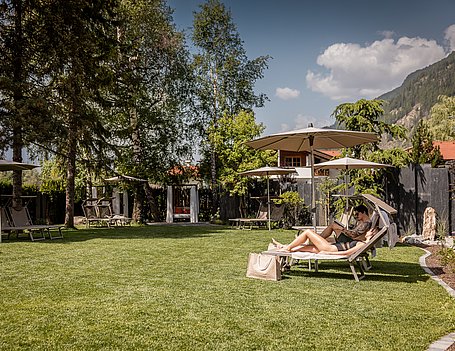 Frau und Mann im Hotelgarten beim Sonnen